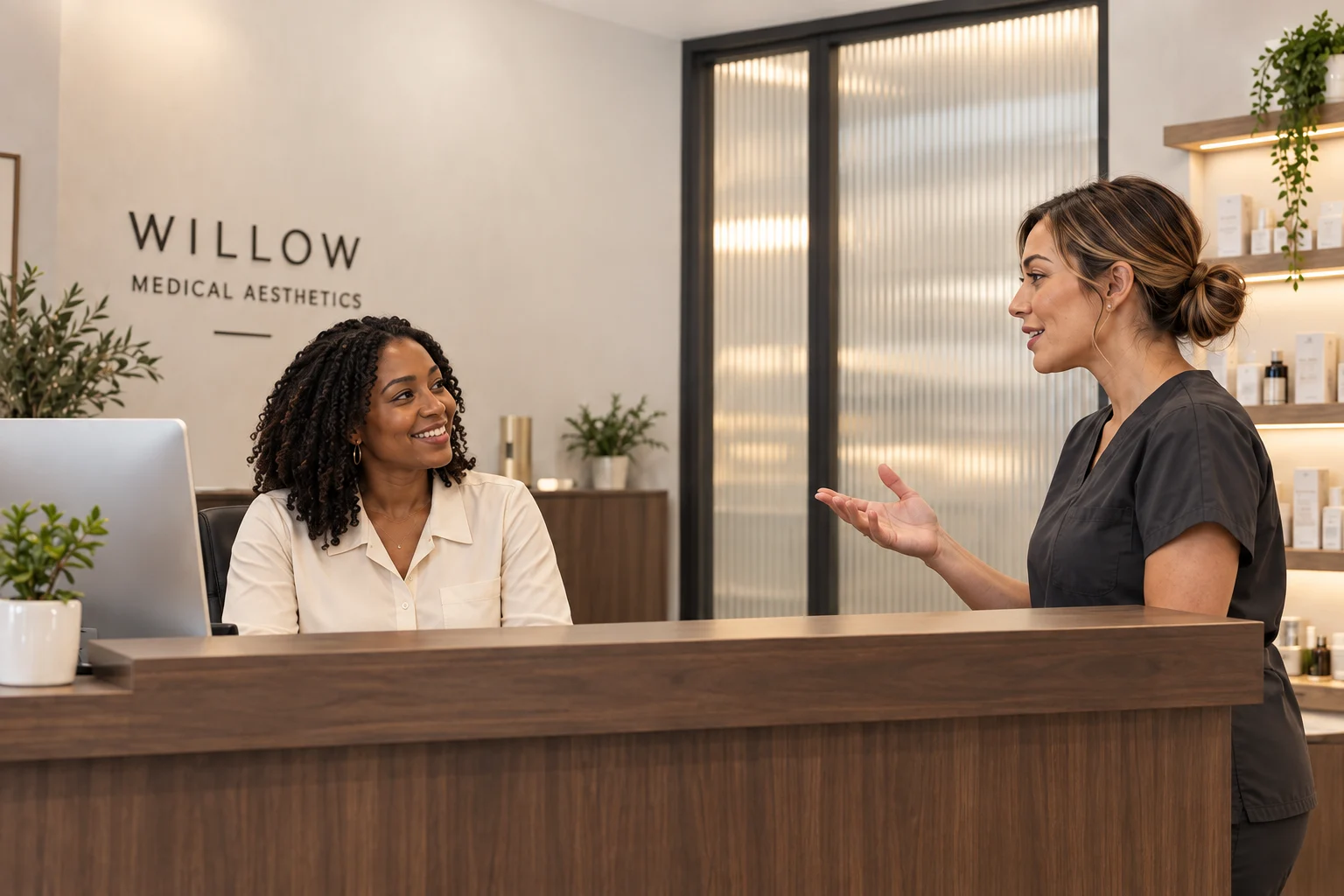A receptionist and a clinician talking at the front desk of a small aesthetic clinic.